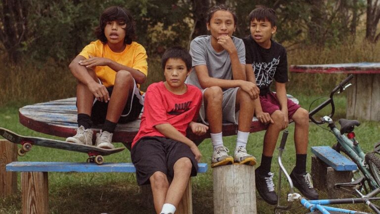 Four Indigenous youths sitting outside, possibly related to War Pony.