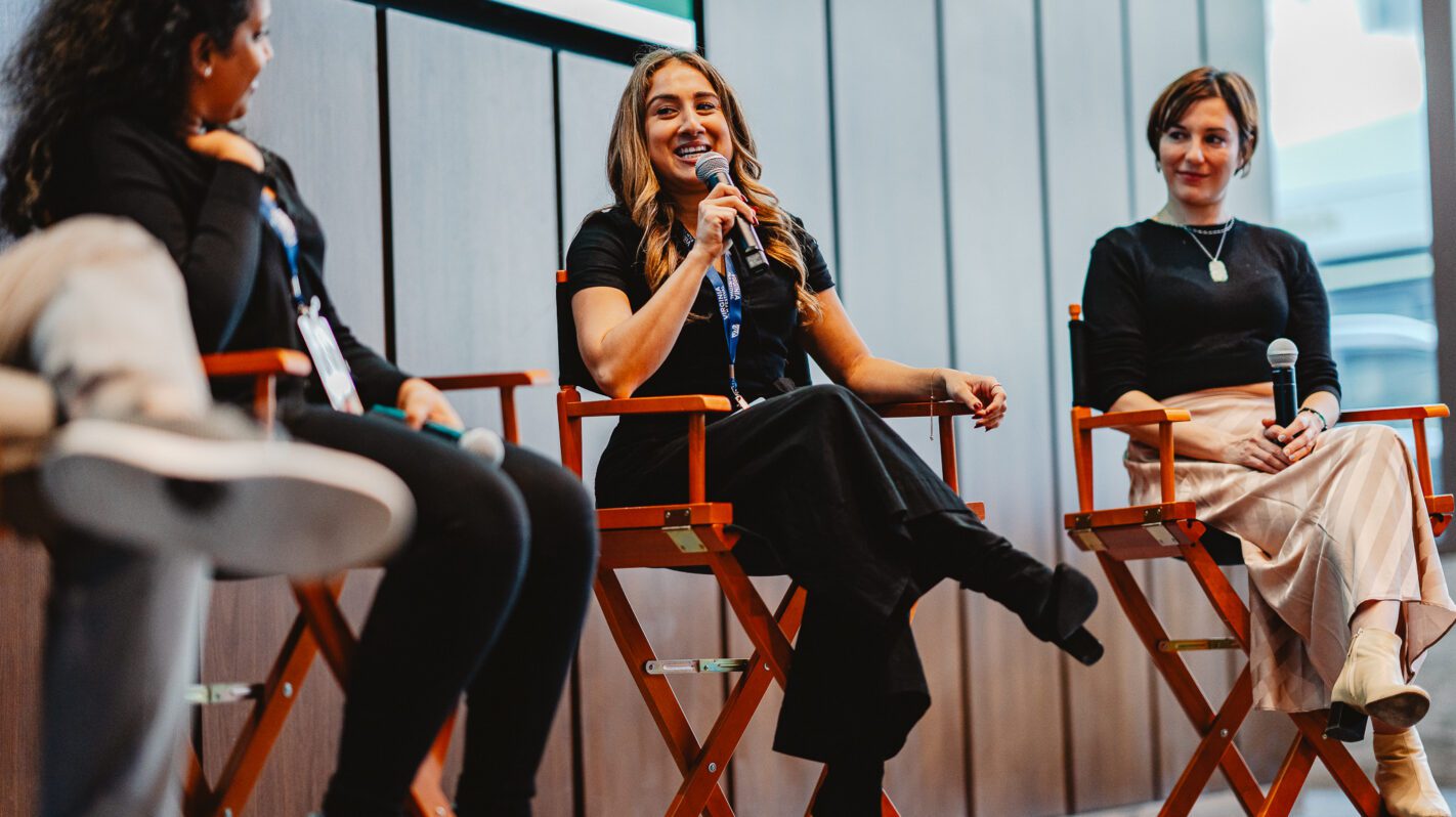 Panel discussion at NEA 2025 event with three women speakers.