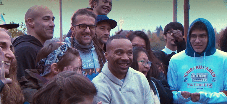Diverse group of people smiling outdoors, possibly related to "Cellblocks To Mountaintops.