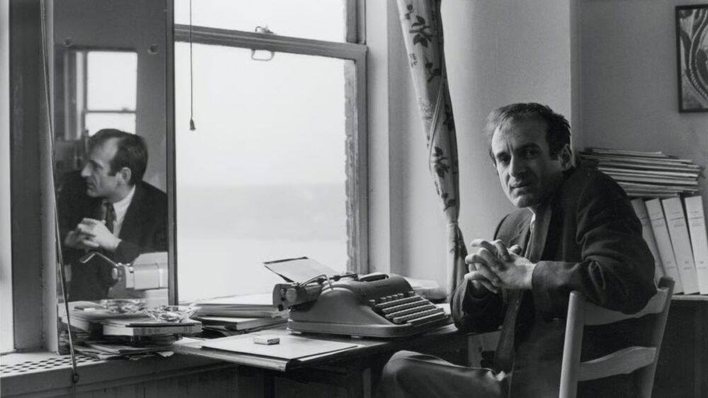 Elie Wiesel at his typewriter, reflected in a window. Author portrait.