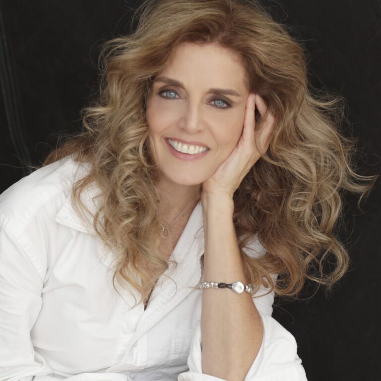 Gina M. Angelone portrait: Smiling woman with blonde curly hair and blue eyes.
