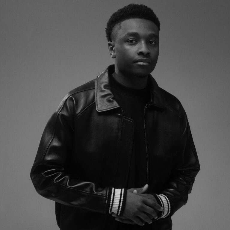 Black and white portrait of Miles Caton in a leather jacket.