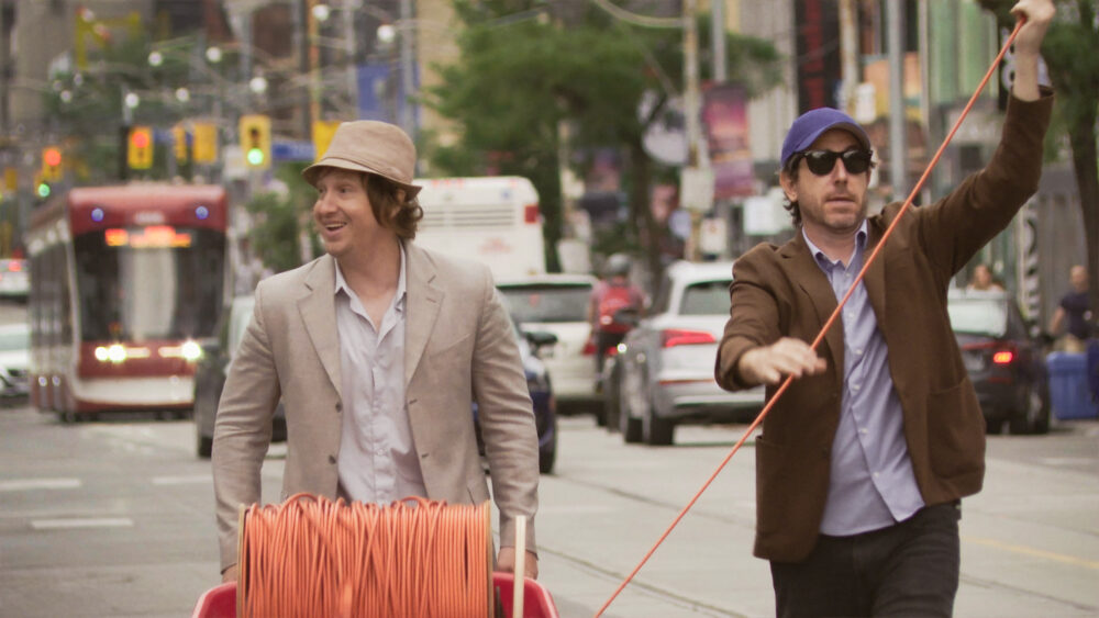 Nirvanna the Band the Show the Movie: Two men with cable on a city street.