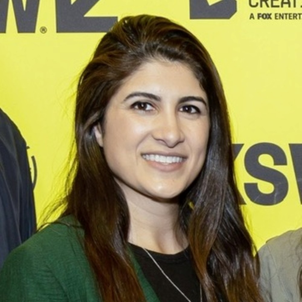 Saba Zerehi smiles at a SXSW event with a yellow backdrop.