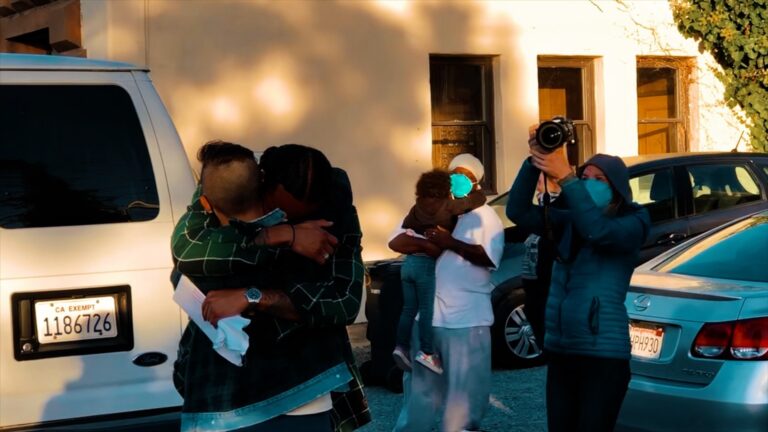 Emotional reunion: People hugging, photographer taking pictures.