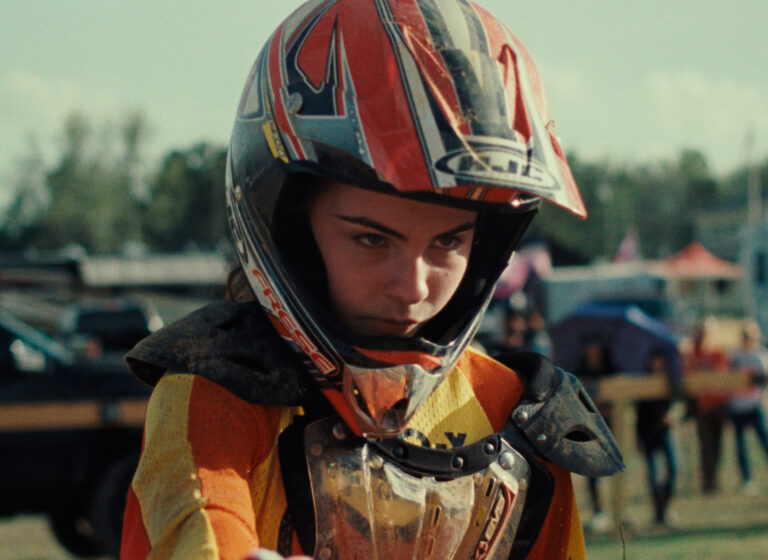 Scene from Ragamuffin. Young dirt biker in helmet and gear.