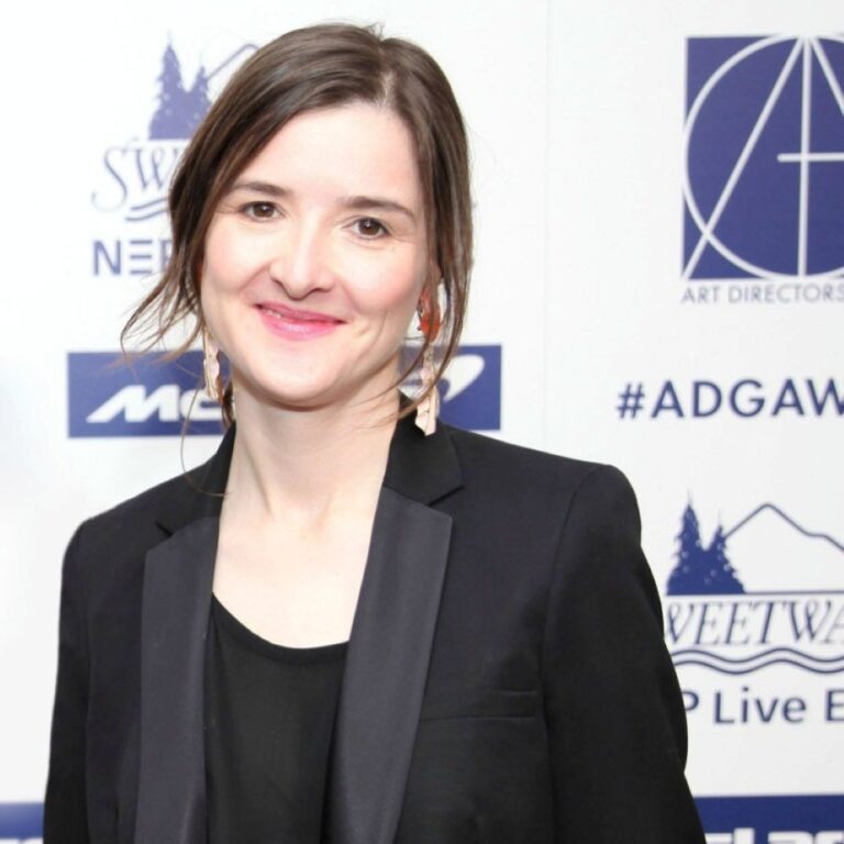 Cara Brower at the Art Directors Guild Awards in a black blazer, smiling.